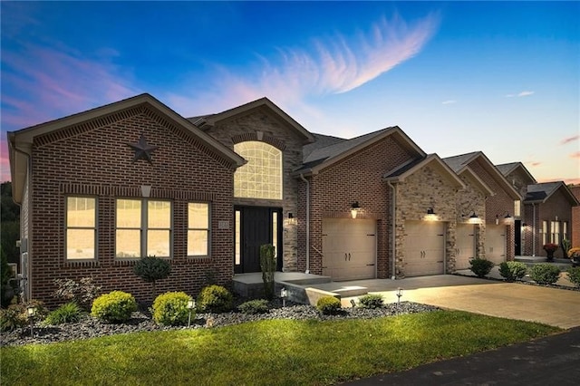 view of front of home featuring a garage, concrete driveway, and brick siding