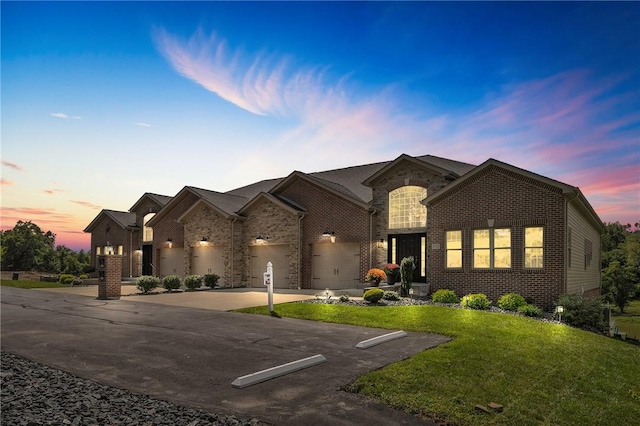 view of front facade featuring a front yard, concrete driveway, brick siding, and an attached garage