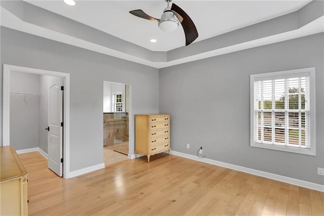 unfurnished bedroom with light wood finished floors, recessed lighting, a closet, a spacious closet, and baseboards