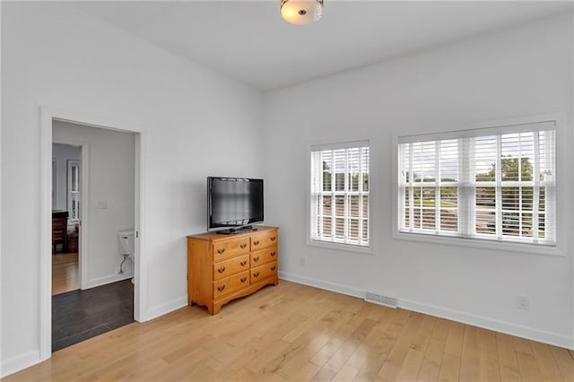 bedroom with light wood-type flooring, visible vents, and baseboards