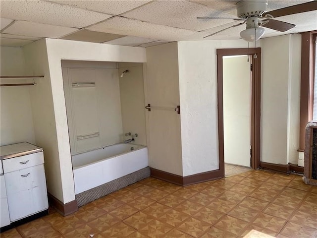 bathroom with a paneled ceiling, shower / bath combination, and ceiling fan