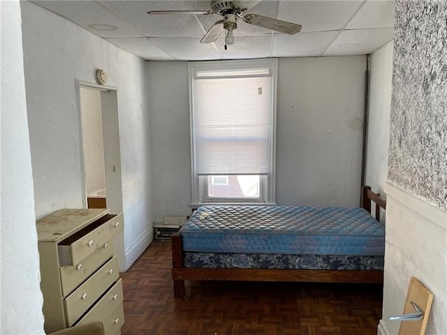 bedroom featuring a paneled ceiling, ceiling fan, and dark parquet flooring