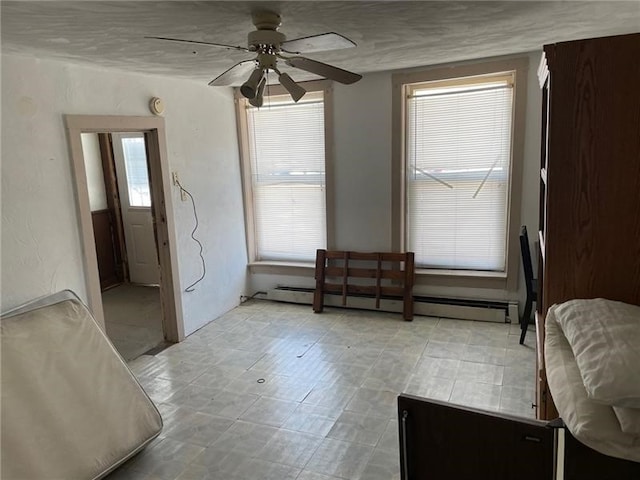 sitting room with ceiling fan, baseboard heating, and light tile patterned floors