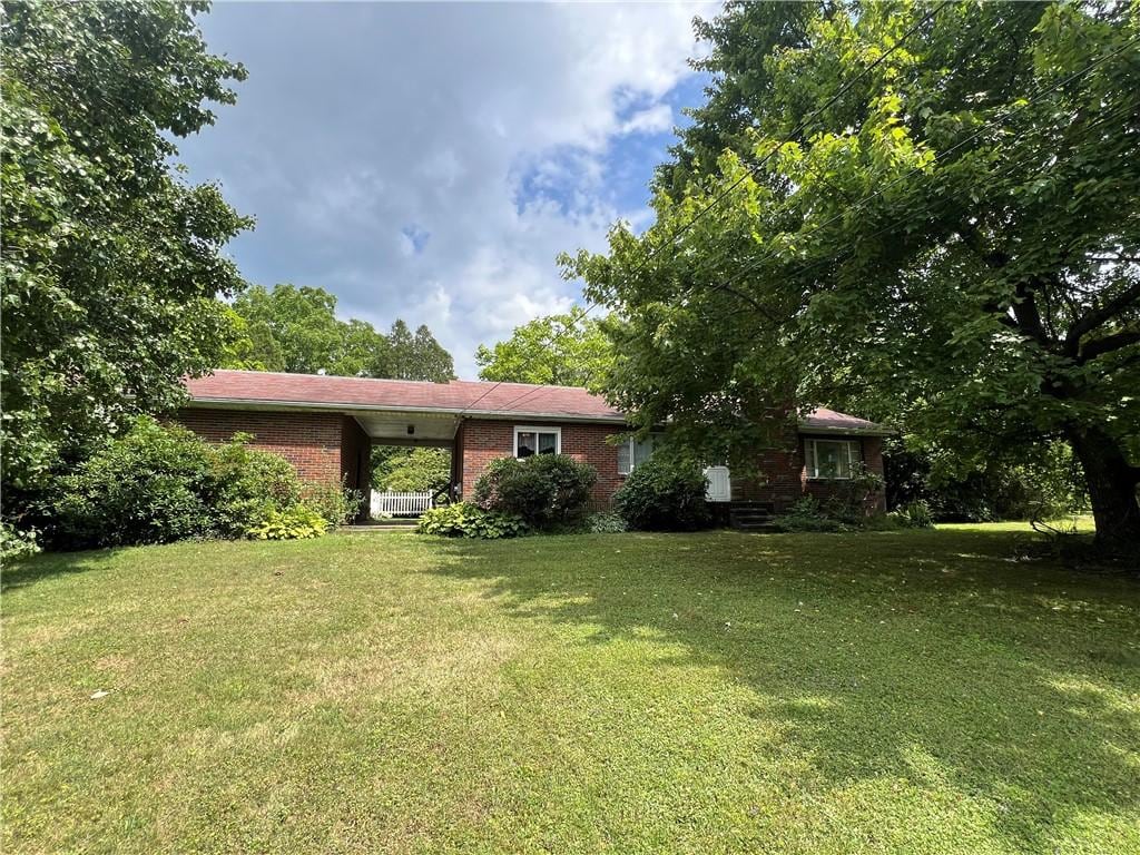 ranch-style home featuring a front lawn