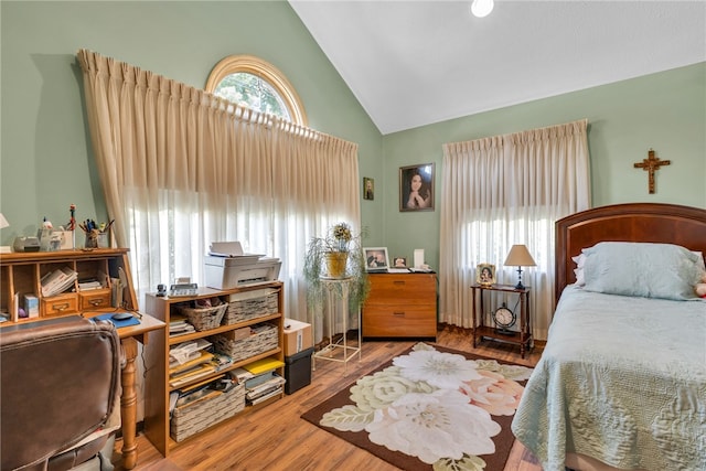 bedroom with hardwood / wood-style flooring and high vaulted ceiling