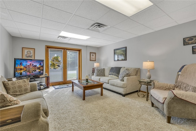 carpeted living room featuring a paneled ceiling