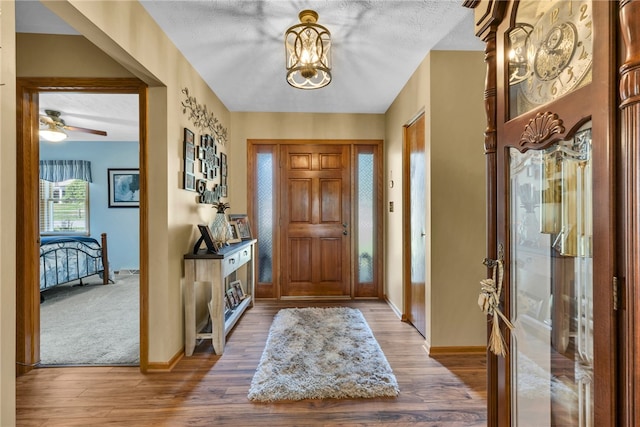 carpeted entrance foyer featuring a textured ceiling and ceiling fan