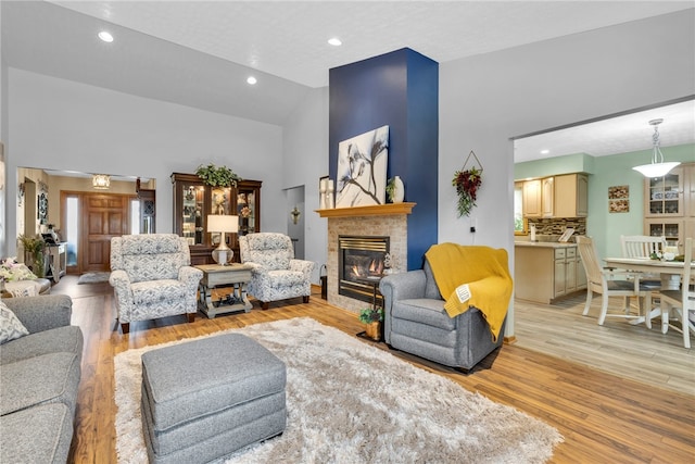 living room featuring light hardwood / wood-style flooring and high vaulted ceiling