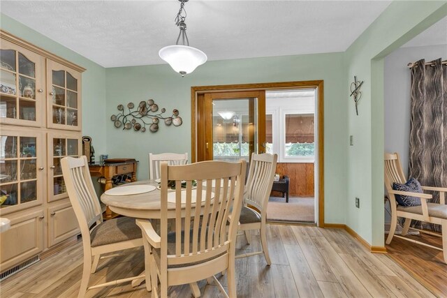 dining room featuring light hardwood / wood-style floors and a textured ceiling