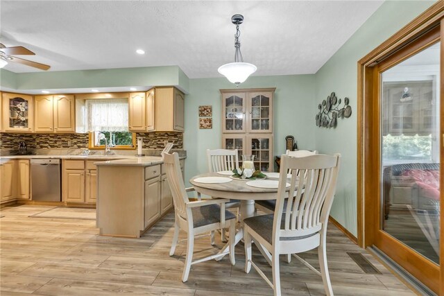 kitchen featuring light brown cabinetry, ceiling fan, tasteful backsplash, dishwasher, and light hardwood / wood-style floors