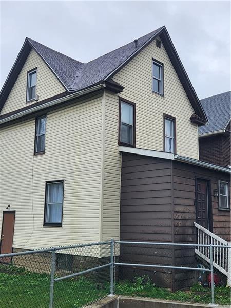 view of side of property featuring a shingled roof and fence