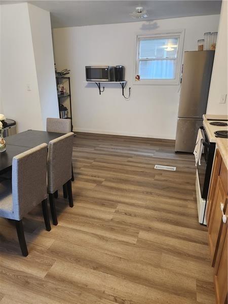 kitchen featuring stainless steel fridge, hardwood / wood-style floors, and electric stove