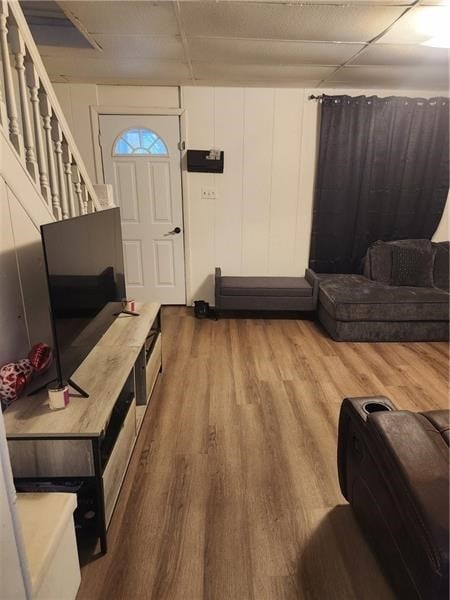 living room featuring a paneled ceiling and wood-type flooring