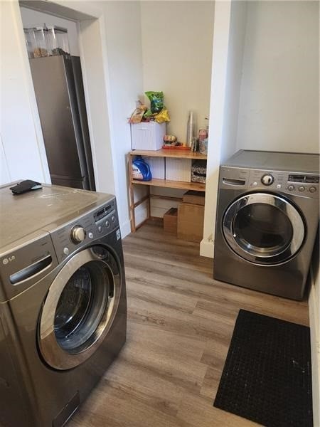 laundry room featuring light hardwood / wood-style floors and independent washer and dryer