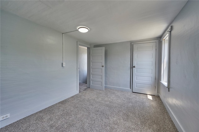 unfurnished bedroom featuring light colored carpet and a closet