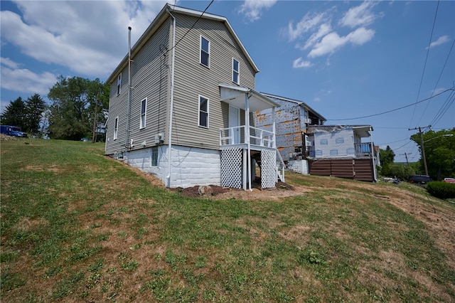 view of side of home with a yard and a deck