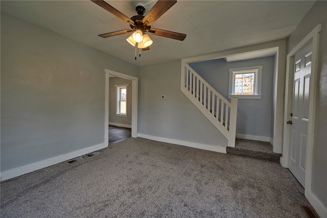 empty room featuring dark colored carpet and ceiling fan