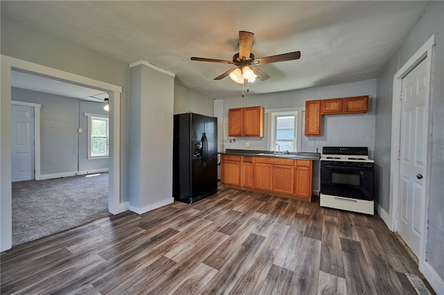 kitchen with black fridge, dark hardwood / wood-style flooring, sink, ceiling fan, and white gas stove