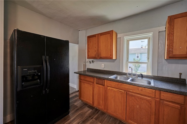 kitchen featuring black refrigerator with ice dispenser, sink, and dark wood-type flooring