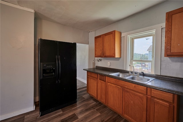 kitchen featuring black refrigerator with ice dispenser, dark hardwood / wood-style floors, and sink