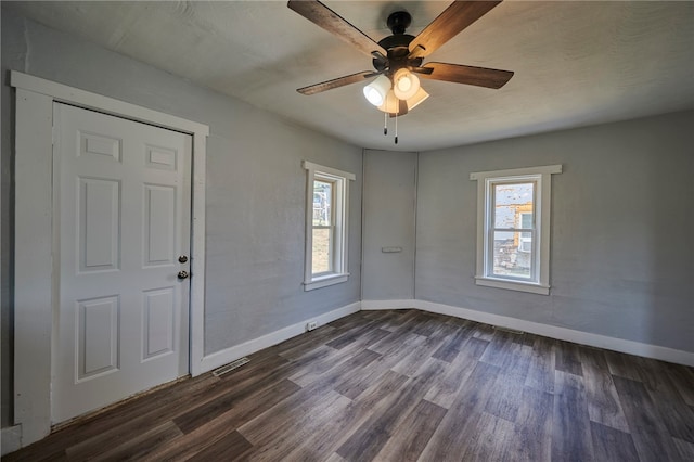 unfurnished room with ceiling fan and dark hardwood / wood-style floors