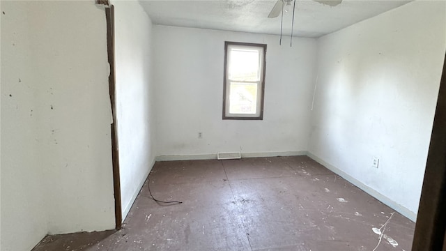 unfurnished room featuring ceiling fan and baseboards