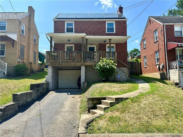 view of front of house featuring a porch, a garage, and a front yard