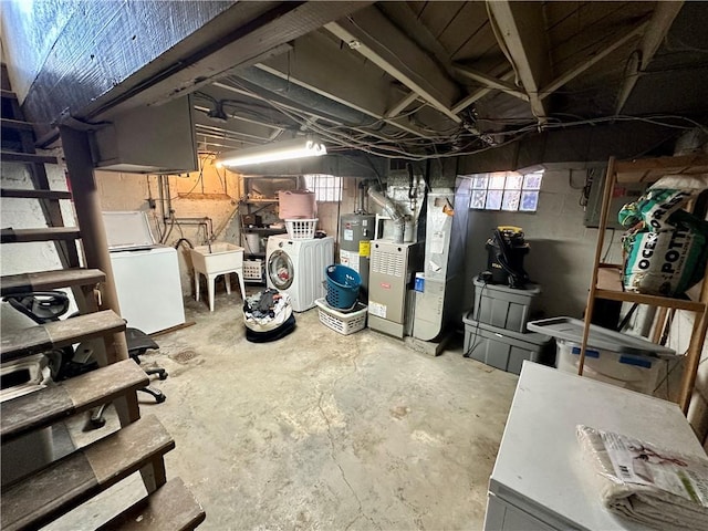 basement featuring washer and clothes dryer, sink, and water heater