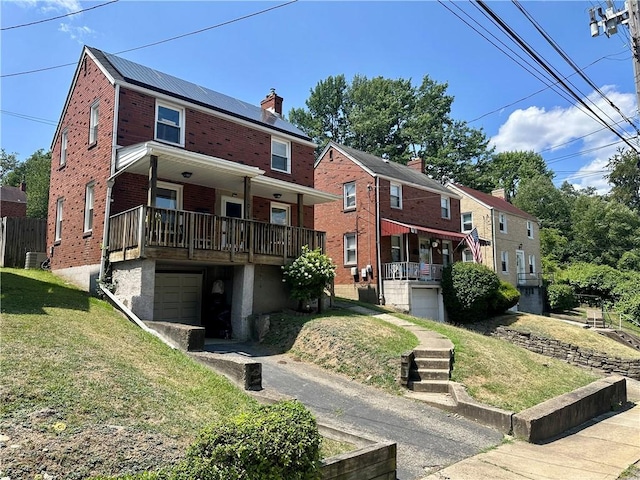 rear view of property featuring a garage and a yard