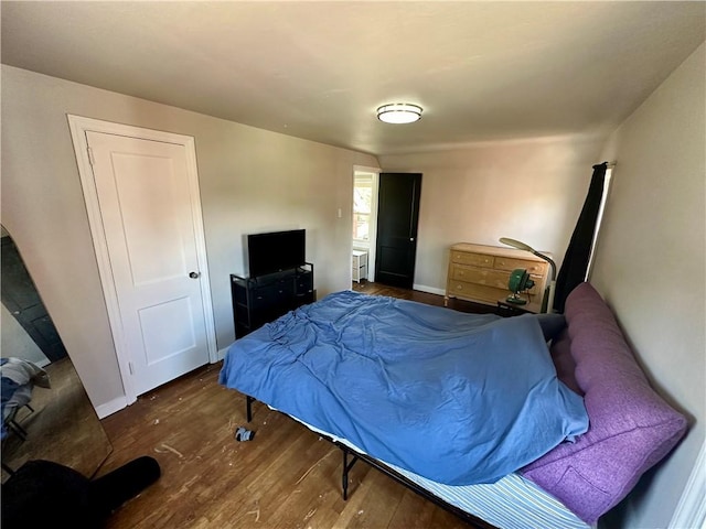 bedroom with dark hardwood / wood-style flooring