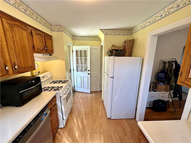 kitchen with light wood-type flooring and white appliances