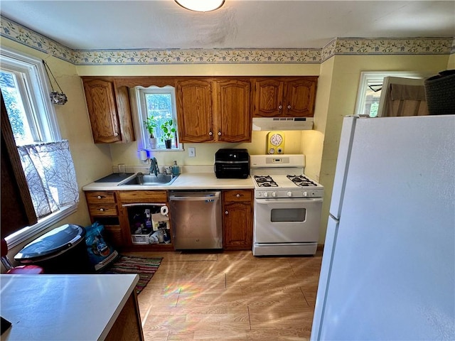 kitchen with a healthy amount of sunlight, sink, and white appliances