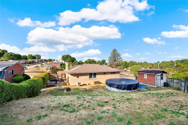 rear view of property with a covered pool