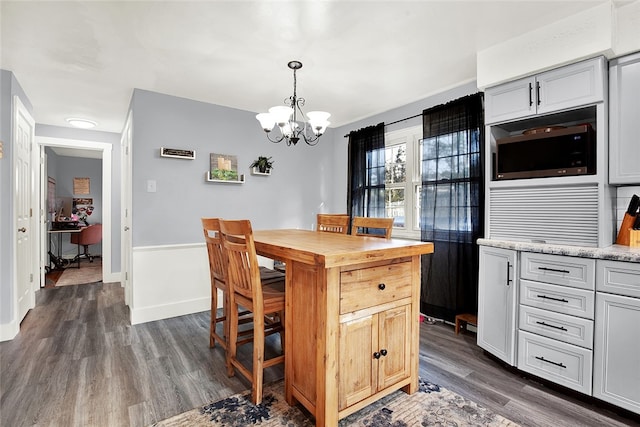 kitchen with a notable chandelier, pendant lighting, stainless steel microwave, dark hardwood / wood-style floors, and gray cabinetry