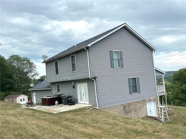 rear view of house with a patio and a lawn