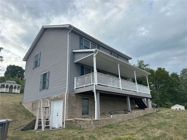 back of property with a balcony and a yard