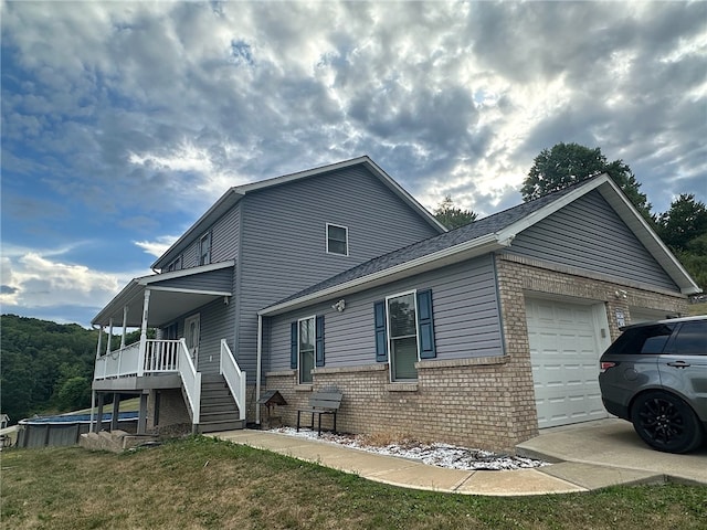 exterior space featuring a garage, a porch, and a front yard