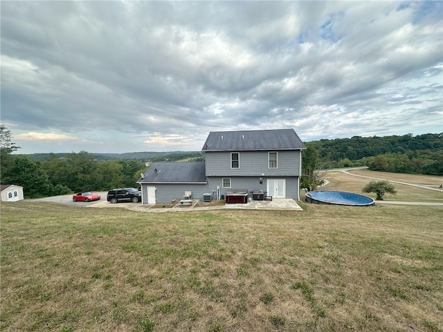 view of front of home featuring a storage unit and a front yard