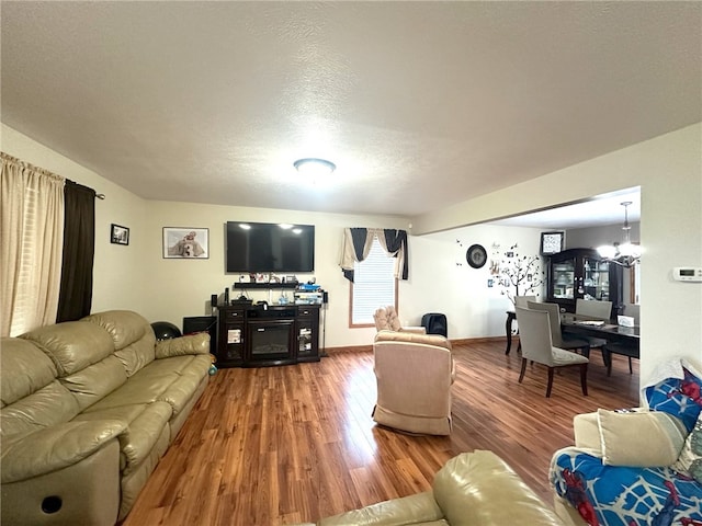 living room featuring a chandelier, a textured ceiling, and hardwood / wood-style floors