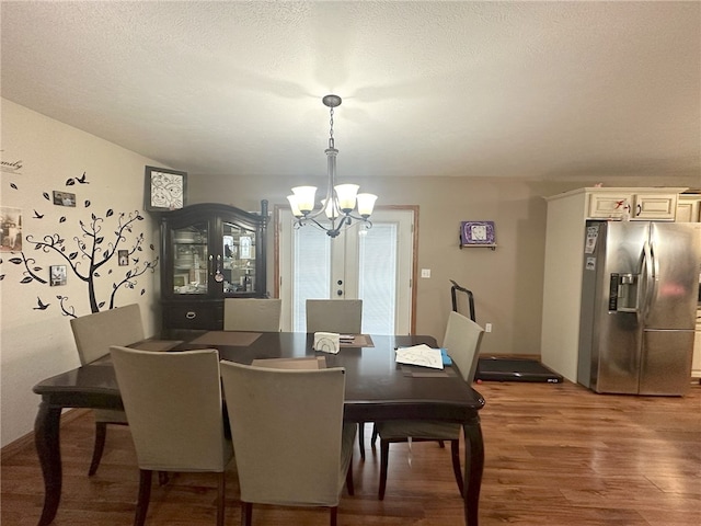 dining area featuring a chandelier, a textured ceiling, french doors, and wood-type flooring