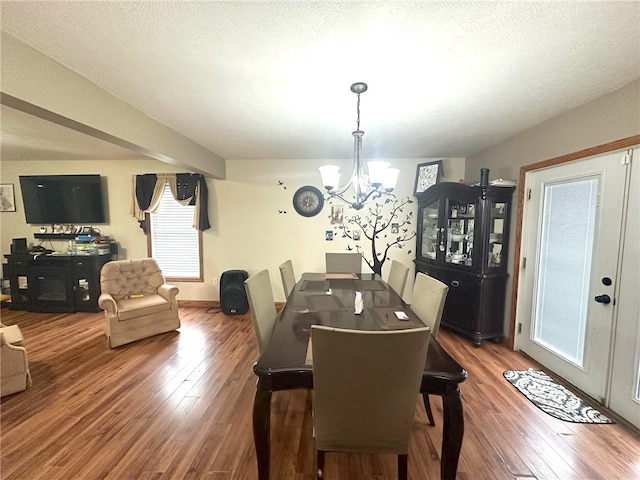 dining space with a notable chandelier, a healthy amount of sunlight, and hardwood / wood-style flooring