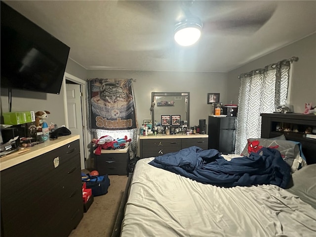 bedroom with ceiling fan, carpet flooring, and black refrigerator