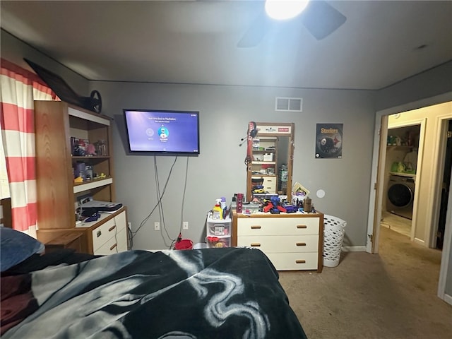 bedroom with carpet floors, washer / dryer, and ceiling fan