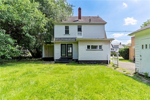 rear view of property with a lawn