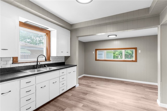 kitchen featuring plenty of natural light, backsplash, sink, and light hardwood / wood-style floors