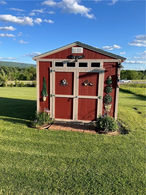 view of outbuilding featuring a lawn