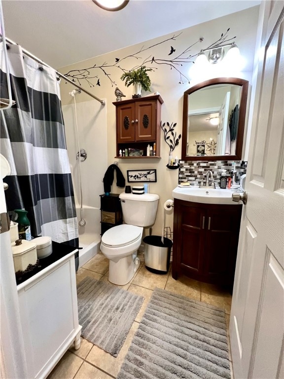 bathroom featuring toilet, walk in shower, tile patterned flooring, vanity, and tasteful backsplash