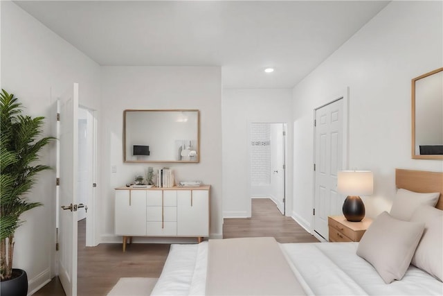 bedroom with recessed lighting, wood finished floors, and baseboards