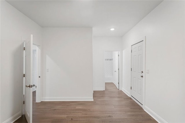 hallway featuring recessed lighting, baseboards, and wood finished floors