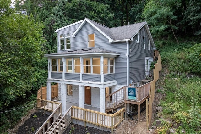 view of front of house with stairs and roof with shingles